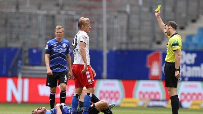 Referee Felix Zwayer HAMBURG, GERMANY - MAY 24: Referee Felix Zwayer shows Joel Pohjanpalo of Hamburger a yellow card after a foul against Fabian Klos of Bielefeld during the Second Bundesliga match between Hamburger SV and DSC Arminia Bielefeld at Volksparkstadion on May 24, 2020 in Hamburg, Germany. (Photo by Christian Charisius/Pool via Getty Images)