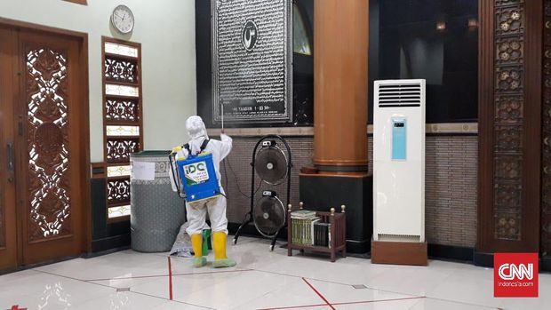 Petugas yang mengenakan alat pelindung diri (APD) langsung menyemprot seluruh bagian Masjid Agung Al-Barkah, Kota Bekasi, Jawa Barat dengan cairan disinfektan usai menggelar salat Jumat berjamaah pada Jumat (29/5).
