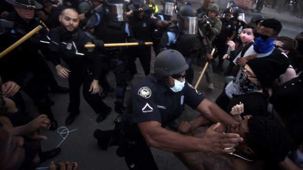 Police officers and protesters clash near CNN Center, Friday, May 29, 2020, in Atlanta, in response to George Floyd's death in police custody in Minneapolis on Memorial Day. The protest started peacefully earlier in the day before demonstrators clashed with police. (AP Photo/Mike Stewart)