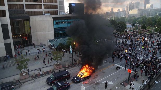 A police car burns after protesters marched to the Georgia State Capitol and returned to the area around the Centennial Olympic Park and CNN center where some confronted police Friday, May 29, 2020, in Atlanta. The protesters carried signs and chanted messages of outrage over the death of George Floyd, a handcuffed back man who died Memorial Day in the custody of the Minneapolis police. (Alyssa Pointer/Atlanta Journal-Constitution via AP)