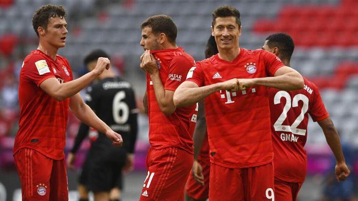 Bayern Munich Munich players, from left, Benjamin Pavard, Lucas Hernandez and Robert Lewandowski, celebrate taking the score to 3:0 against Fortuna Dsseldorf, during their Bundesliga soccer match played without an audience in Munich, Germany, Saturday May 30, 2020. Soccer matches are being played without an audience because of the coronavirus pandemic. (Christof Stache/Pool via AP)