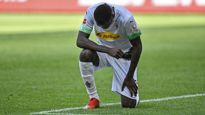 Moenchengladbachs Marcus Thuram taking the knee after scoring his sides second goal during the German Bundesliga soccer match between Borussia Moenchengladbach and Union Berlin in Moenchengladbach, Germany, Sunday, May 31, 2020. The German Bundesliga becomes the worlds first major soccer league to resume after a two-month suspension because of the coronavirus pandemic. (AP Photo/Martin Meissner, Pool)