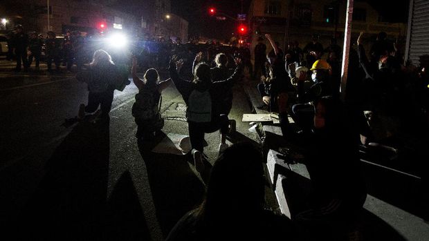 Protesters wait to be arrested Sunday, May 31, 2020, in Los Angeles, during a demonstration over the death of George Floyd, who died May 25 after he was pinned at the neck by a Minneapolis police officer. (AP Photo/Ringo H.W. Chiu)