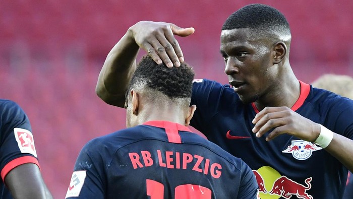 Leipzigs French midfielder Christopher Nkunku, left, celebrates with Leipzigs French defender Nordi Mukiele after he scores his side second goal during the German Bundesliga soccer match between 1. FC Cologne and RB Leipzig, in Cologne, Germany, Monday, June 1, 2020. Because of the coronavirus outbreak all soccer matches of the German Bundesliga take place without spectators. (Ina Fassbender/Pool via AP)