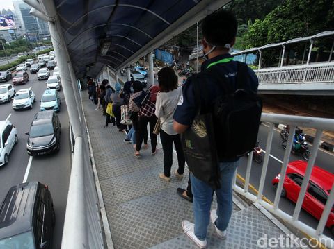 Antrean penumpang bus TransJakarta terlihat di Halte Gatot Subroto. Antrean itu disebabkan oleh warga yang kembali beraktivitas jelang penerapan new normal.