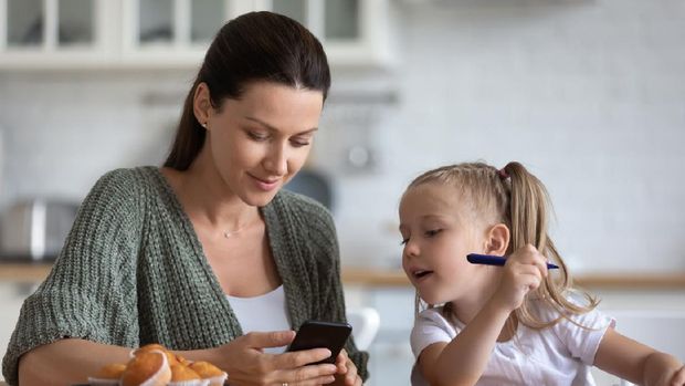 Orang tua menggunakan ponsel atau gadget depan anak
