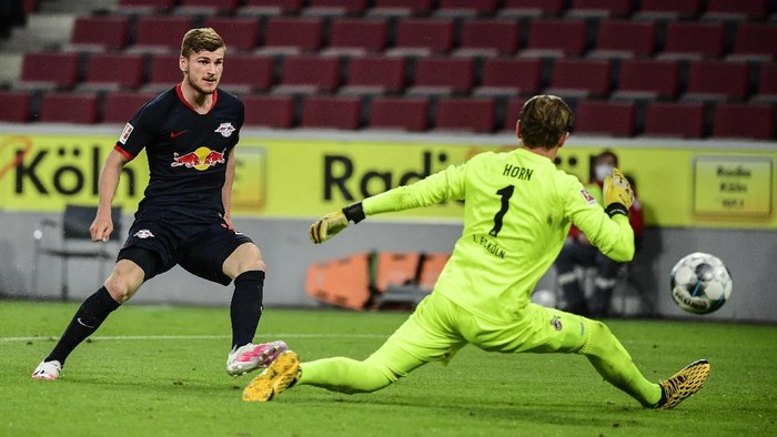 Leipzigs German forward Timo Werner, left, scores his side third goal past Colognes German goalkeeper Timo Horn during the German Bundesliga soccer match between 1. FC Cologne and RB Leipzig, in Cologne, Germany, Monday, June 1, 2020. Because of the coronavirus outbreak all soccer matches of the German Bundesliga take place without spectators. (Ina Fassbender/Pool via AP)