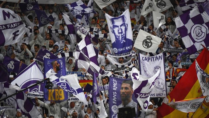 Real Madrid fans holding pictures of Real Madrids French coach Zinedine Zidane (top), Real Madrids Spanish defender Sergio Ramos (R) and Real Madrids French forward Karim Benzema (L) cheer for their team before the Spanish League football match between Real Madrid and Barcelona at the Santiago Bernabeu stadium in Madrid on March 1, 2020. (Photo by GABRIEL BOUYS / AFP)