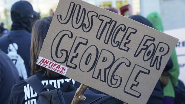 antifa A poster with the inscription 'Justice for George' and 'Antifa on the offensive' is held by a protestor during a demonstration under the motto