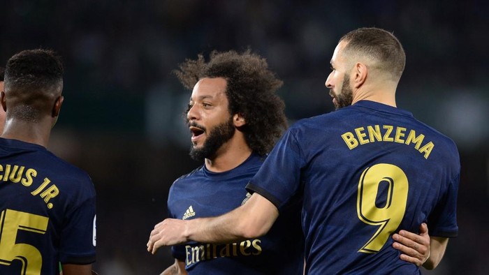 Real Madrids French forward Karim Benzema (R) celebrates after scoring a goal with Real Madrids Brazilian defender Marcelo (C)  during the Spanish league football match between Real Betis and Real Madrid CF at the Benito Villamarin stadium in Seville on March 8, 2020. (Photo by CRISTINA QUICLER / AFP)