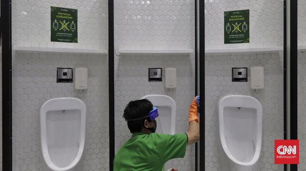 Petugas membersihkan fasilitas toilet dengan berstiker tanda jaga jarak di Mal Central Park, Jakarta, Rabu (3/6/2020). CNN Indonesia/Adhi Wicaksono