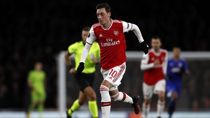 Arsenals German midfielder Mesut Ozil runs with the ball during the UEFA Europa league round of 32 second leg football match between Arsenal and Olympiakos at the Emirates stadium in London on February 27, 2020. (Photo by Adrian DENNIS / AFP)
