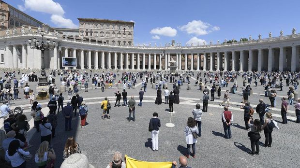 Faithful gather in St. Peter's Square at the Vatican, Sunday, May 31, 2020. Pope Francis has cheerfully greeted people in St. Peter’s Square on Sunday, as he resumed his practice of speaking to the faithful there for the first time since lockdown began in Italy and at the Vatican in early March. Instead of the tens of thousands of people who might have turned out on a similarly brilliantly sunny day like this Sunday, in pre-pandemic times, perhaps a few hundred came to the square, standing well apart from others or in small family groups (Vatican News via AP)