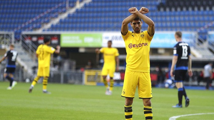 Achraf Hakimi Mouh of Borussia Dortmund celebrates scoring his teams fourth goal of the game during the German Bundesliga soccer match between SC Paderborn 07 and Borussia Dortmund at Benteler Arena in Paderborn, Germany, Sunday, May 31, 2020. Because of the coronavirus outbreak all soccer matches of the German Bundesliga take place without spectators. (Lars Baron/Pool via AP)