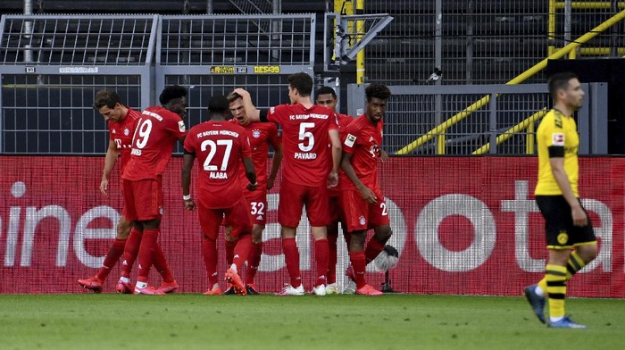 Munichs scorer Joshua Kimmich, center, and his teammates celebrate the opening goal during the German Bundesliga soccer match between Borussia Dortmund and FC Bayern Munich in Dortmund, Germany, Tuesday, May 26, 2020. The German Bundesliga is the worlds first major soccer league to resume after a two-month suspension because of the coronavirus pandemic. (Federico Gambarini/DPA via AP, Pool)