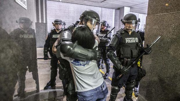 A protester hugs a police officer who kneeled after protesters attending a rally against the deaths of George Floyd and Breonna Taylor chanted 
