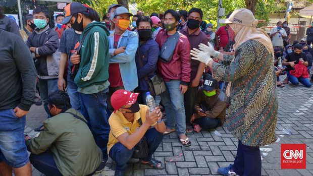 Warga Surabaya antre berdesakan tanpa menerapkan protokol kesehatan seperti physical distancing, dan penggunaan masker, saat mengikuti rapid test yang diadakan Badan Intelijen Negara (BIN), Kamis (4/6).