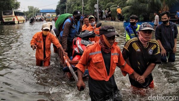 Potret Warga Terobos Banjir Rob di Muara Baru
