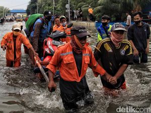 Potret Warga Terobos Banjir Rob di Muara Baru