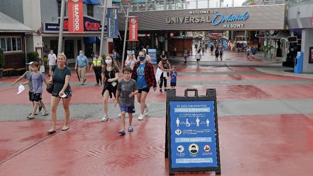 Universal Orlando Resort In this Wednesday, June 3, 2020 photo, signs about social distancing and other protocols are seen about the theme park as guests walk by at Universal Orlando Resort Wednesday, June 3, 2020, in Orlando, Fla. The theme park reopened for season pass holders and will open to the general public on Friday, June 5. (AP Photo/John Raoux)