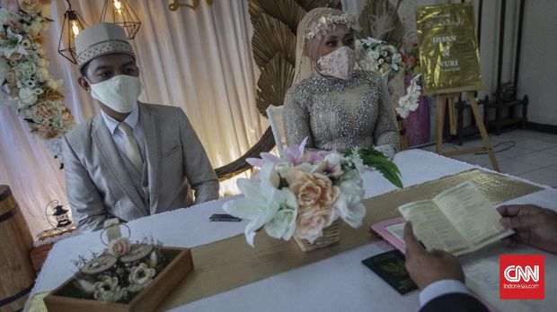 Suasana akad nikah di Kantor Urusan Agama (KUA) kecamatan Ciracas, Jakarta, Sabtu, 6 Juni 2020. Sesuai dengan SE Nomor 15 Tahun 2020 Tentang Panduan Penyelenggaraan Kegiatan di Rumah Ibadah Dalam Mewujudkan Masyarakat Produktif dan Aman Covid-19 di Masa Pandemi, calon pengantin diharuskan mengikuti protokol kesehatan seperti menggunakan masker dan sarung tangan. CNN Indonesia/Bisma Septalisma