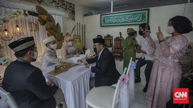 Akad Nikah Saat Transisi PSBB Suasana akad nikah di Kantor Urusan Agama (KUA) kecamatan Ciracas, Jakarta, Sabtu, 6 Juni 2020. Sesuai dengan SE Nomor 15 Tahun 2020 Tentang Panduan Penyelenggaraan Kegiatan di Rumah Ibadah Dalam Mewujudkan Masyarakat Produktif dan Aman Covid-19 di Masa Pandemi, calon pengantin diharuskan mengikuti protokol kesehatan seperti menggunakan masker dan sarung tangan. CNN Indonesia/Bisma Septalisma
