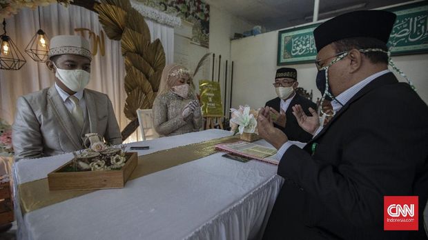 Akad Nikah Saat Transisi PSBB Suasana akad nikah di Kantor Urusan Agama (KUA) kecamatan Ciracas, Jakarta, Sabtu, 6 Juni 2020. Sesuai dengan SE Nomor 15 Tahun 2020 Tentang Panduan Penyelenggaraan Kegiatan di Rumah Ibadah Dalam Mewujudkan Masyarakat Produktif dan Aman Covid-19 di Masa Pandemi, calon pengantin diharuskan mengikuti protokol kesehatan seperti menggunakan masker dan sarung tangan. CNN Indonesia/Bisma Septalisma
