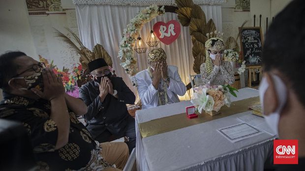 Suasana akad nikah di Kantor Urusan Agama (KUA) kecamatan Ciracas, Jakarta, Sabtu, 6 Juni 2020. Sesuai dengan SE Nomor 15 Tahun 2020 Tentang Panduan Penyelenggaraan Kegiatan di Rumah Ibadah Dalam Mewujudkan Masyarakat Produktif dan Aman Covid-19 di Masa Pandemi, calon pengantin diharuskan mengikuti protokol kesehatan seperti menggunakan masker dan sarung tangan. CNN Indonesia/Bisma Septalisma