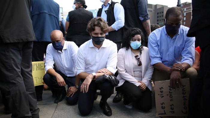 Canadian Prime Minister Justin Trudeau (2nd L) takes a knee during in a Black Lives Matter protest on Parliament Hill June 5, 2020 in Ottawa, Canada. - Canadian Prime Minister Justin Trudeau appeared at a loss for words on June 2, pausing for 20 seconds when pressed for this thoughts on US President Donald Trumps threat of military mobilization against violent US protests. (Photo by Dave Chan / AFP)