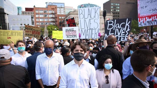 Justin Trudeau saat bergabung dalam aksi solidaritas memprotes rasialisme usai kematian George Floyd yang digelar di depan gedung parlemen Kanada Canadian Prime Minister Justin Trudeau (C) takes part in a Black Lives Matter protest on Parliament Hill June 5, 2020 in Ottawa, Canada. - Canadian Prime Minister Justin Trudeau appeared at a loss for words on June 2, pausing for 20 seconds when pressed for this thoughts on US President Donald Trump's threat of military mobilization against violent US protests. (Photo by Dave Chan / AFP)