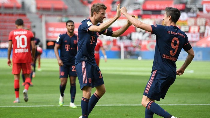 LEVERKUSEN, GERMANY - JUNE 06: Robert Lewandowski of Muenchen celebrates his teams fourth goal with teammate Thomas Mueller during the Bundesliga match between Bayer 04 Leverkusen and FC Bayern Muenchen at BayArena on June 06, 2020 in Leverkusen, Germany. (Photo by Matthias Hangst/Getty Images)
