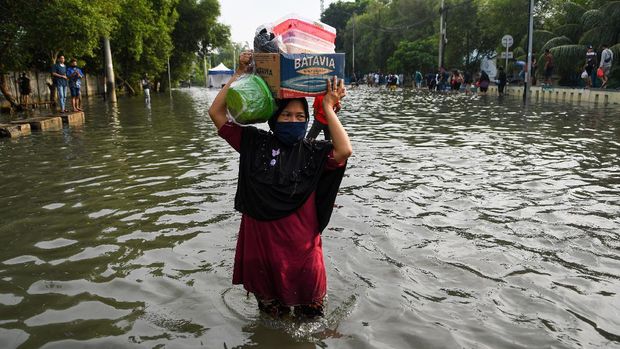 Warga melintasi banjir air rob di kawasan Muara Baru, Penjaringan, Jakarta Utara, Jumat (5/6/2020). Menurut Badan Meteorologi, Klimatologi, dan Geofisika (BMKG) rob disebabkan oleh kondisi pasang air laut yang cukup tinggi di beberapa wilayah Indonesia akibat fase bulan purnama. ANTARA FOTO/M Risyal Hidayat/wsj.
