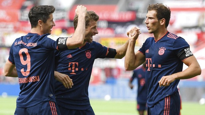 Robert Lewandowski, left, of Munich celebrates his teams fourth goal with teammates Thomas Mueller, center, and Leon Goretzka during the German Bundesliga soccer match between Bayer Leverkusen and Bayern Munich in Leverkusen, Germany, Saturday, June 6, 2020. (Matthias Hangst, Pool via AP)
