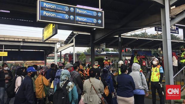 Sejumlah penumpang stasiun Bekasi mengantre untuk masuk ke dalam kereta pda hri pertama pemberlakuan PSBB Transisi, Senin (8/6)