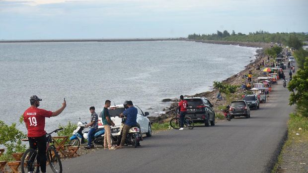 Pengunjung menikmati suasana di kawasan wisata pantai Ulee Lheue dan Kampung Jawa, Banda Aceh, Aceh, Minggu (7/6/2020). Sejumlah objek wisata pantai di daerah tersebut kembali ramai pengunjung dan pedagang kuliner keliling, yang sebagian besar tidak menerapkan protokol kesehatan untuk mencegah penyebaran COVID-19. ANTARA FOTO/Ampelsa/aww..