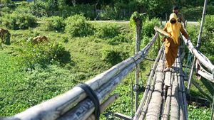 Potret Guru Lewati Jembatan Bambu untuk Antar Soal Ujian