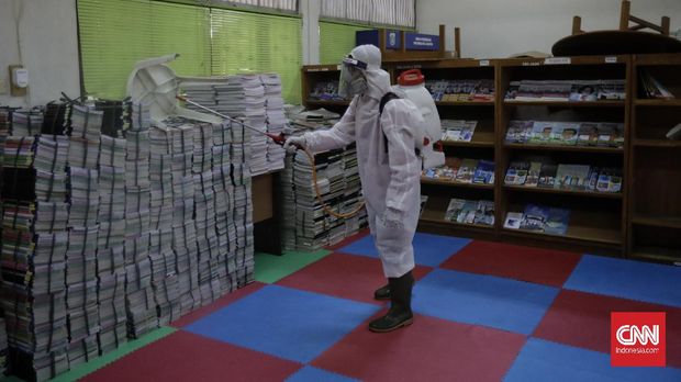 Penyemprotan Disinfektan di Sekolah Anggota Palang Merah Indonesia menyemprotkan desinfektan dalam upaya menahan penyebaran virus corona di dalam ruang kelas di SMPN 139 dan SDN Malaka Jaya 04 Pagi. Jakarta, Selasa, 9 Juni 2020. (CNN Indonesia/ Adhi Wicaksono)