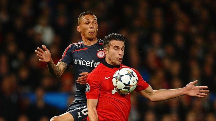 MANCHESTER, ENGLAND - MARCH 19:  Robin van Persie of Manchester United is fouled in the penalty box by Jose Holebas of Olympiacos during the UEFA Champions League Round of 16 second round match between Manchester United and Olympiacos FC at Old Trafford on March 19, 2014 in Manchester, England.  (Photo by Laurence Griffiths/Getty Images)