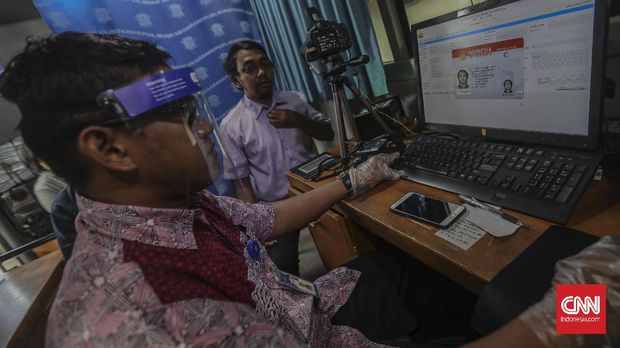 Warga antre mengurus perpanjangan Surat Ijin Mengemudi (SIM) di layanan SIM keliling di Kawasan Masjid Agung At-Tin, Jakarta, Rabu, 10 Juni 2020. Untuk menghindari antrean panjang, pihak Satlantas membatasi jumlah layanan perpanjangan SIM, yakni sebanyak 300 orang per hari, dan dibagi menjadi 3 gelombang. CNN Indonesia/Bisma Septalisma