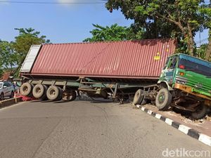 Terperosok ke Parit, Truk Peti Kemas 14 Jam Melintang di Jalan Palembang