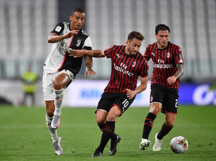 TURIN, ITALY - JUNE 12:  Danilo (L) of Juventus is challenged by Hakan Calhanoglu of AC Milan during the Coppa Italia Semi-Final Second Leg match between Juventus and AC Milan at Allianz Stadium on June 12, 2020 in Turin, Italy.  (Photo by Valerio Pennicino/Getty Images)