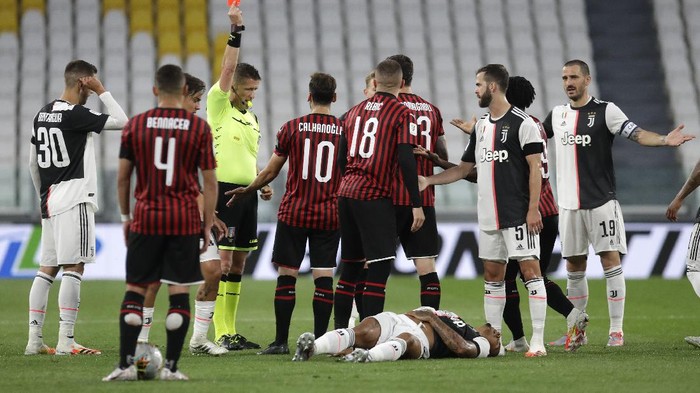 AC Milans Ante Rebic, center, gets a red card during an Italian Cup second leg soccer match between Juventus and AC Milan at the Allianz stadium, in Turin, Italy, Friday, June 12, 2020. The match was being played without spectators because of the coronavirus lockdown. (AP Photo/Luca Bruno)