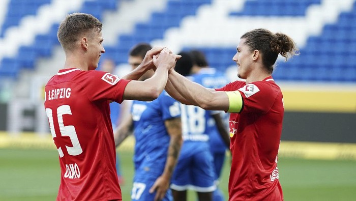 Leipzigs Dani Olmo, left, celebrates after scoring his sides second goal during the German Bundesliga soccer match between 1899 Hoffenheim and RB Leipzig in Sinsheim, Germany, Friday, June 12, 2020. The German Bundesliga is the worlds first major soccer league to resume after a two-month suspension because of the coronavirus pandemic. (Uwe Anspach/DPA via AP, Pool)