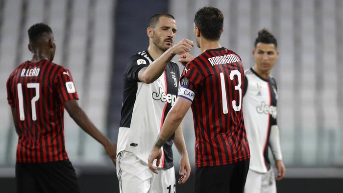 Juventus Leonardo Bonucci, center, greets AC Milans Alessio Romagnoli at the end of an Italian Cup second leg soccer match between Juventus and AC Milan at the Allianz stadium, in Turin, Italy, Friday, June 12, 2020. The match was a 0-0 draw, but Juventus went through on away goals after the first leg ended 1-1. (AP Photo/Luca Bruno)