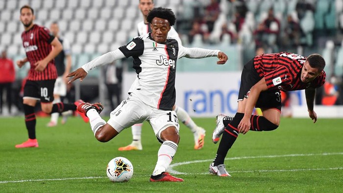TURIN, ITALY - JUNE 12:  Juan Cuadrado (L) of Juventus in action against Rade Krunic of AC Milan during the Coppa Italia Semi-Final Second Leg match between Juventus and AC Milan at Allianz Stadium on June 12, 2020 in Turin, Italy.  (Photo by Valerio Pennicino/Getty Images)