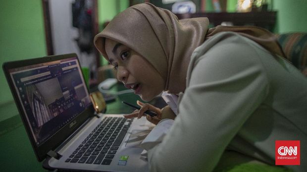 Pelita Mu'minatus Sholihah (21), mahasiswa Teknik Metalurgi dan Material Universitas Indonesia melaksanakan sidang skripsi secara online di kediamannya di kawasan Cimanggis, Depok, Jawa Barat. Sidang skripsi secara online ini menjadi siasat perguruan tinggi untuk mencegah penyebaran virus Covid-19. CNN Indonesia/Bisma Septalisma