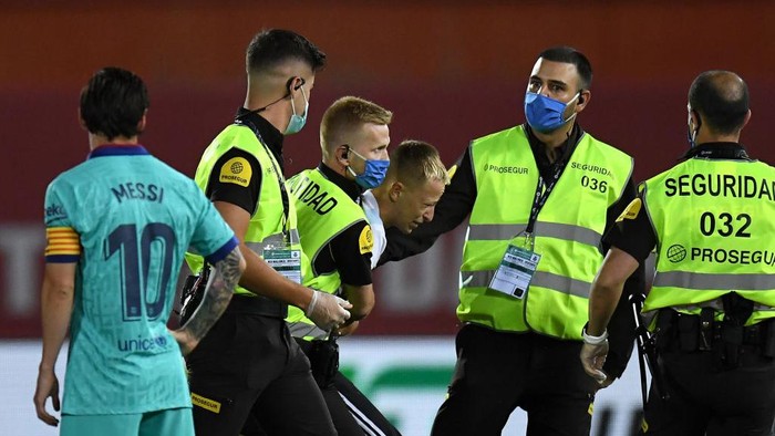 MALLORCA, SPAIN - JUNE 13: A member of the public is dragged away by security guards after invading the pitch during the La Liga match between RCD Mallorca and FC Barcelona at Estadio de Son Moix on June 13, 2020 in Mallorca, Spain. (Photo by David Ramos/Getty Images)