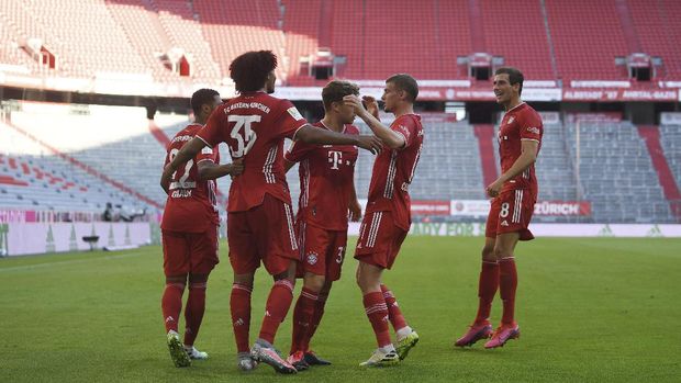 Bayern's Joshua Zirkzee, second from left, celebrates with team mates after he scores the opening goal during the German Bundesliga soccer match between Bayern Munich and Borussia Moenchengladbach in Munich, Germany, Saturday, June 13, 2020. Because of the coronavirus outbreak all soccer matches of the German Bundesliga take place without spectators. (Matthias Balk/Pool via AP)