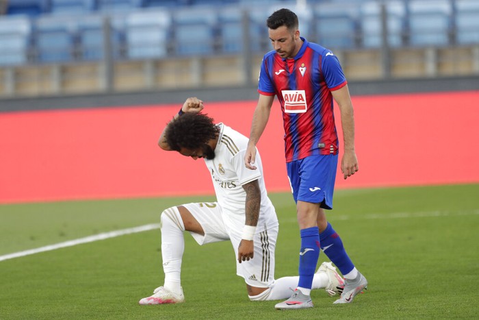Real Madrids Marcelo takes a knee as he celebrates his goal during the Spanish La Liga soccer match between Real Madrid and Eibar at Alfredo di Stefano stadium in Madrid, Spain, Sunday, June 14, 2020. (AP Photo/Bernat Armangue)