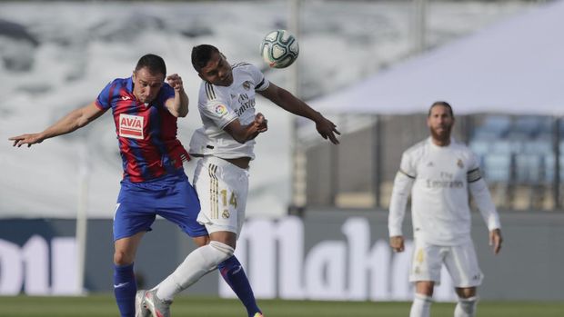 Real Madrid vs Eibar Real Madrid's Casemiro, right, and Eibar's Kike Garcia go for the ball during the Spanish La Liga soccer match between Real Madrid and Eibar at Alfredo di Stefano stadium in Madrid, Spain, Sunday, June 14, 2020. (AP Photo/Bernat Armangue)